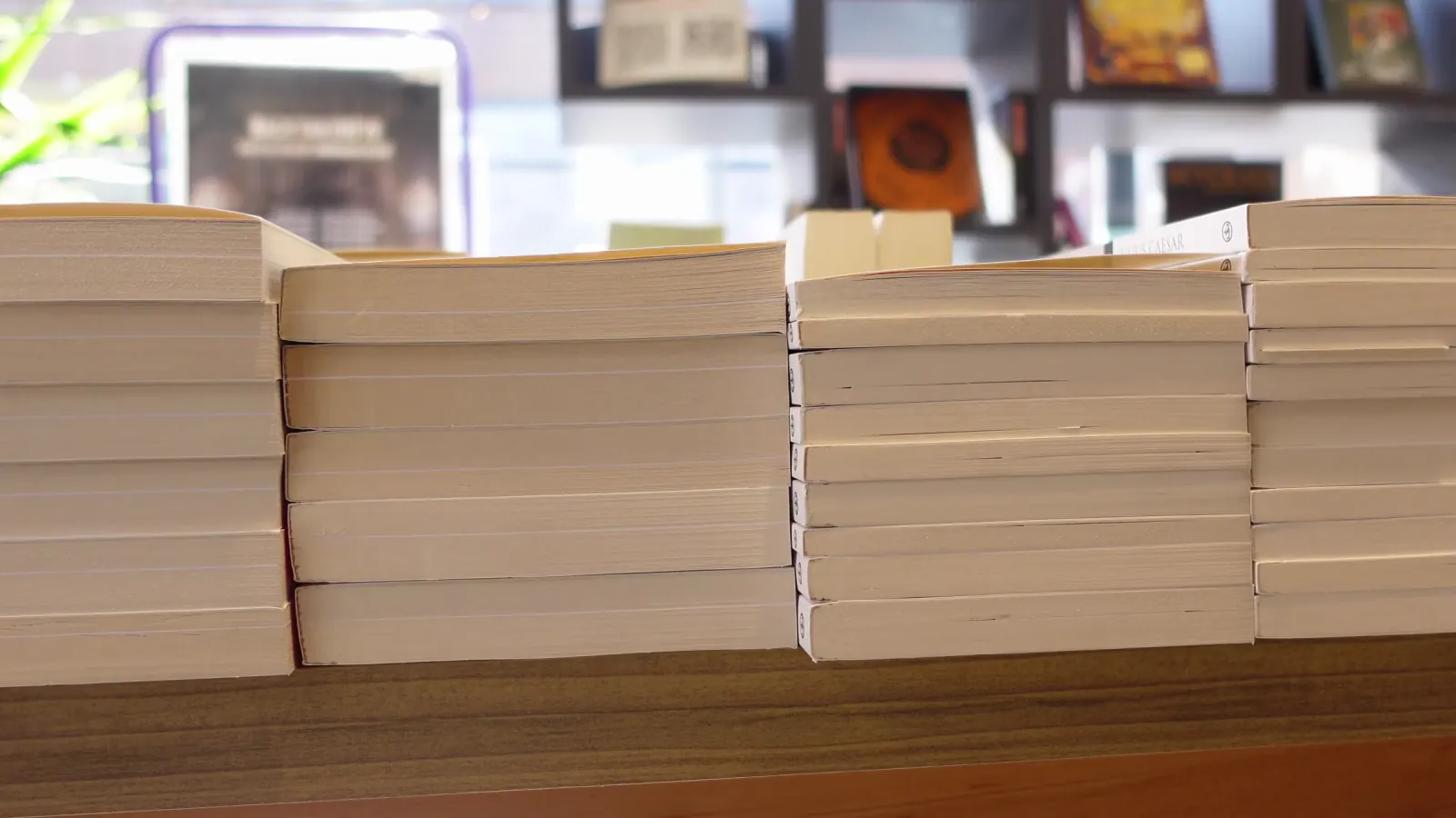 Stacked hardbacks on a bookshop table.